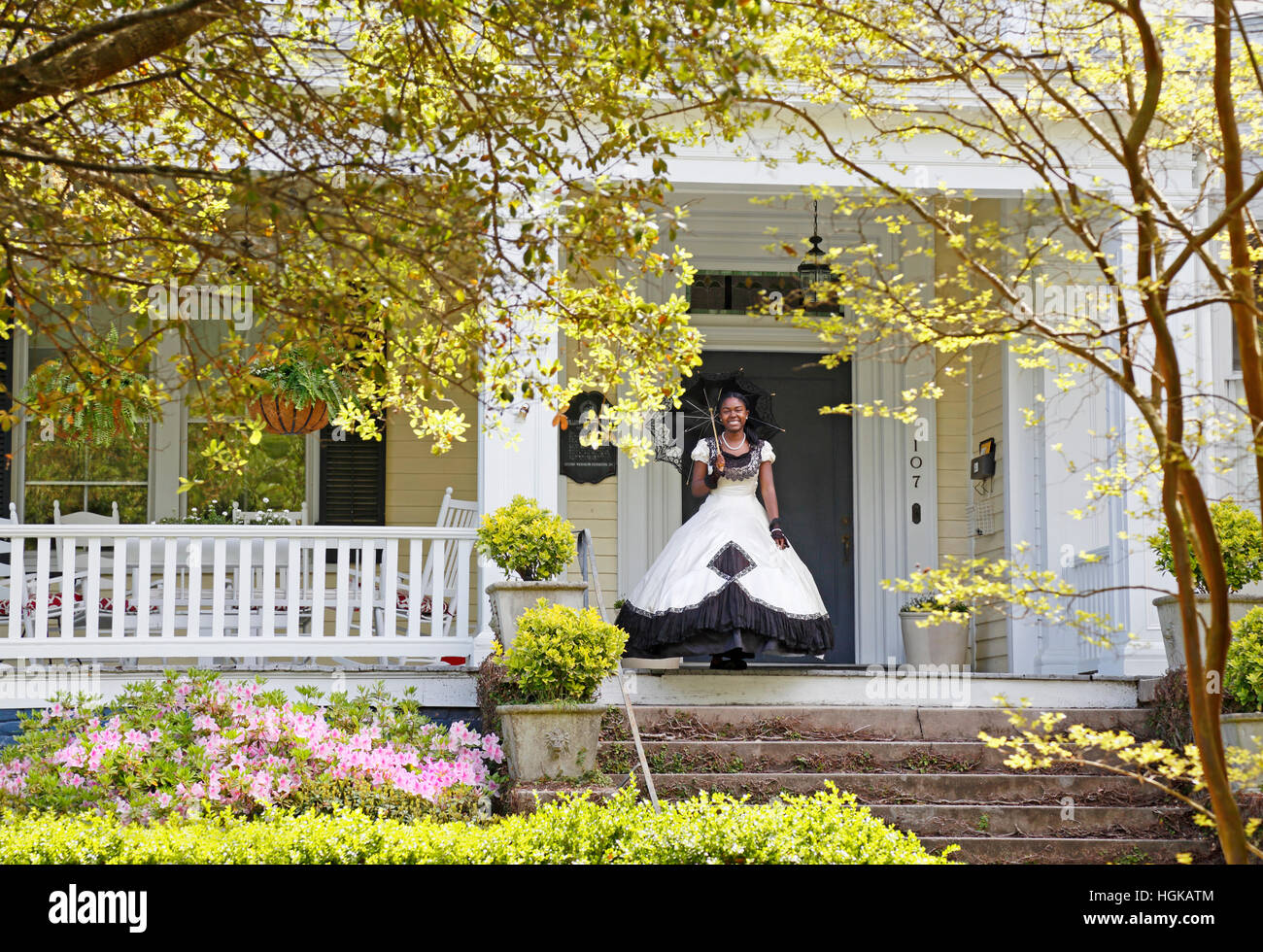 Wilmington, North Carolina. Cape Fear Garden Club Azalea Belle standing on front porch during the annual garden tour. Stock Photo