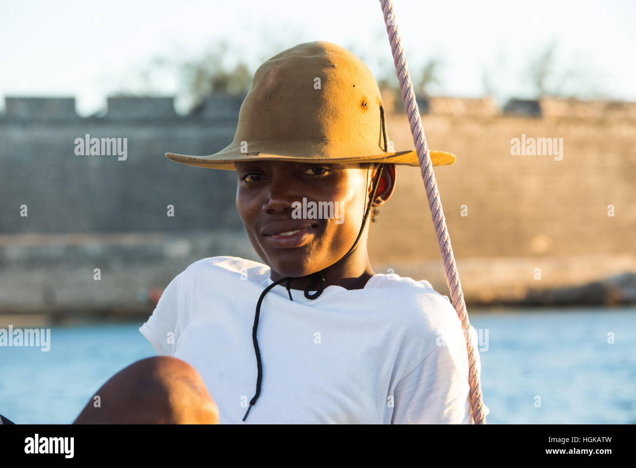 Young man on a dhow in front of the fort, Mozambique Island (Ilha de Mocambique), Mozambique Stock Photo