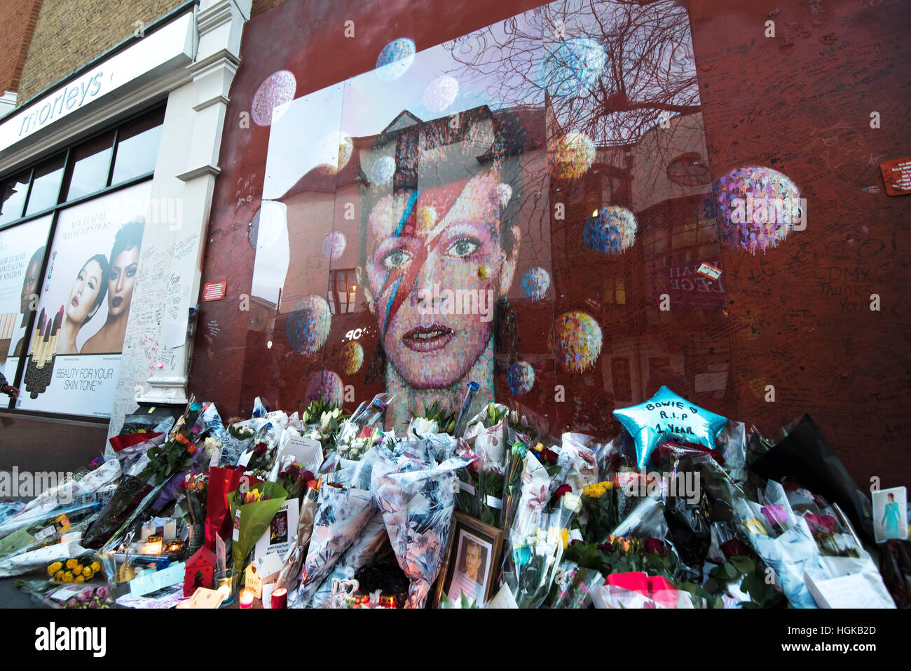 London, UK. 10th January, 2017. Flowers and tributes are placed by an art work of David Bowie on a wall at Brixton, on the first death anniversary of his death, just two days after his 69th birthday in London, UK.Credit: Alberto Pezzali/Pacific Press/Alamy Live News Stock Photo