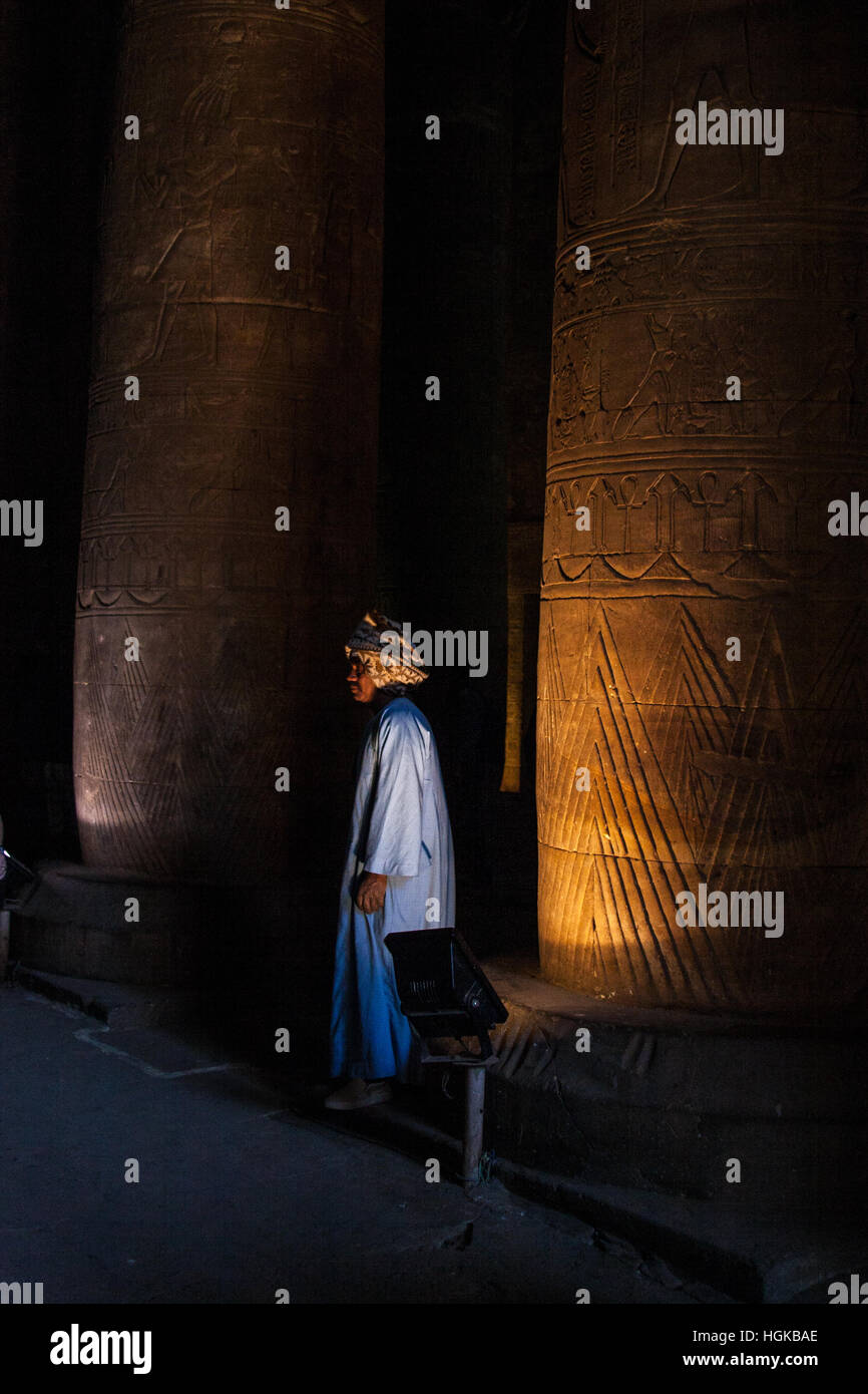 A man stands by one of the columns in the Temple of Edfu in Egypt. It is one of the best preserved temples in Egypt. Stock Photo