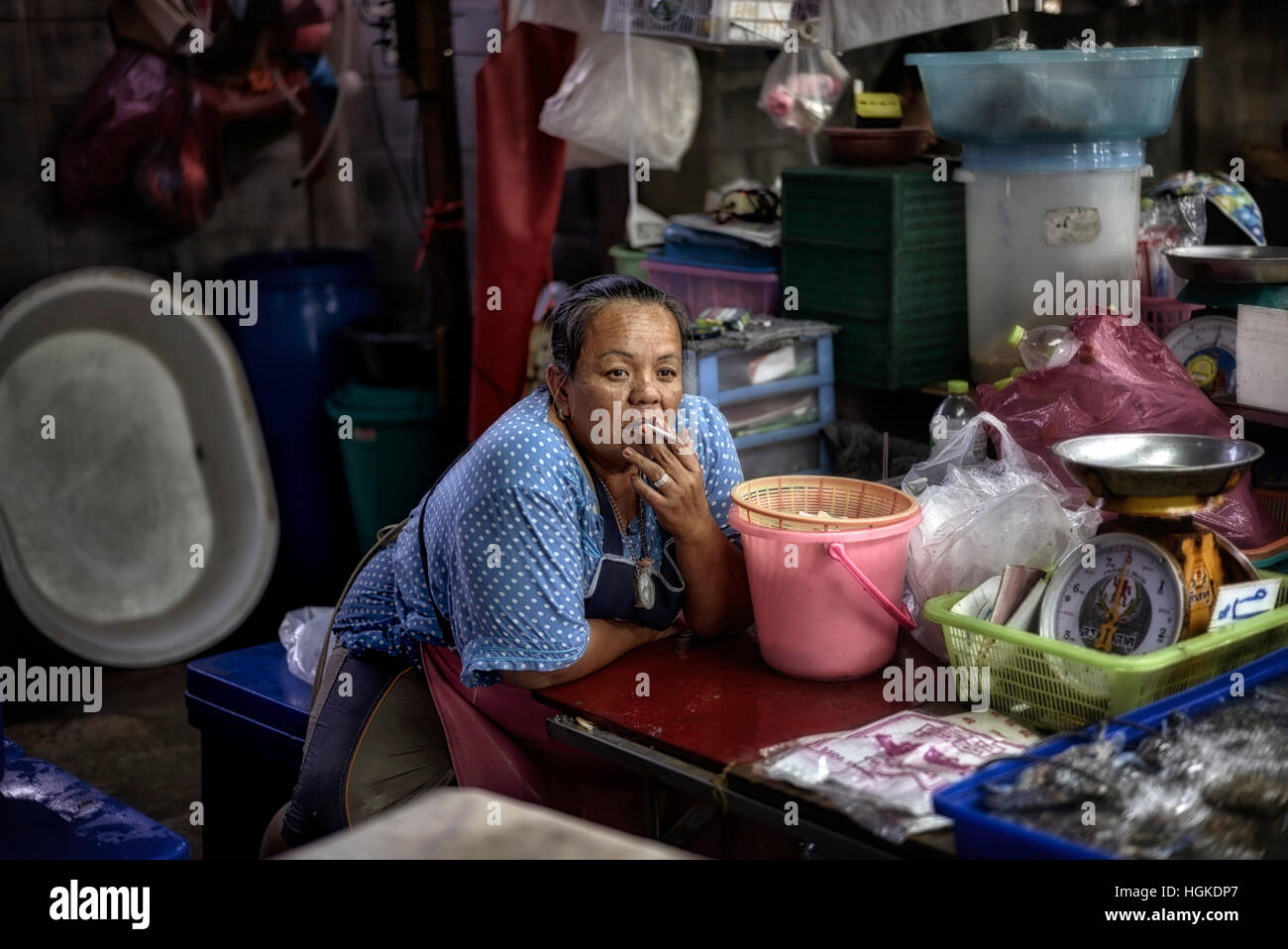 Woman smoking a cigarette at her market stall. Thailand S. E. Asia Stock Photo