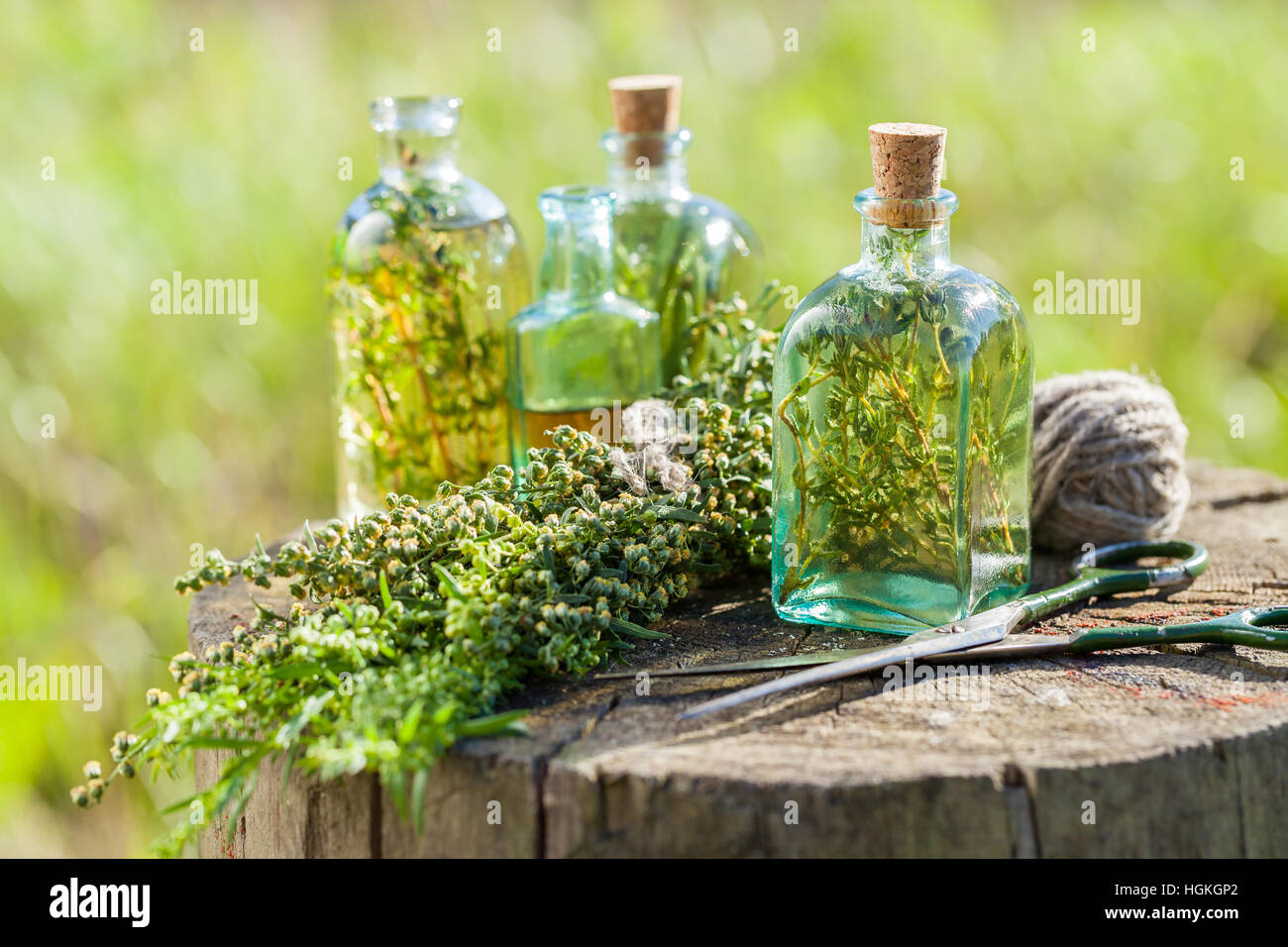 Bottles of thyme, estragon and rosemary essential oil or infusion outdoors, herbal medicine