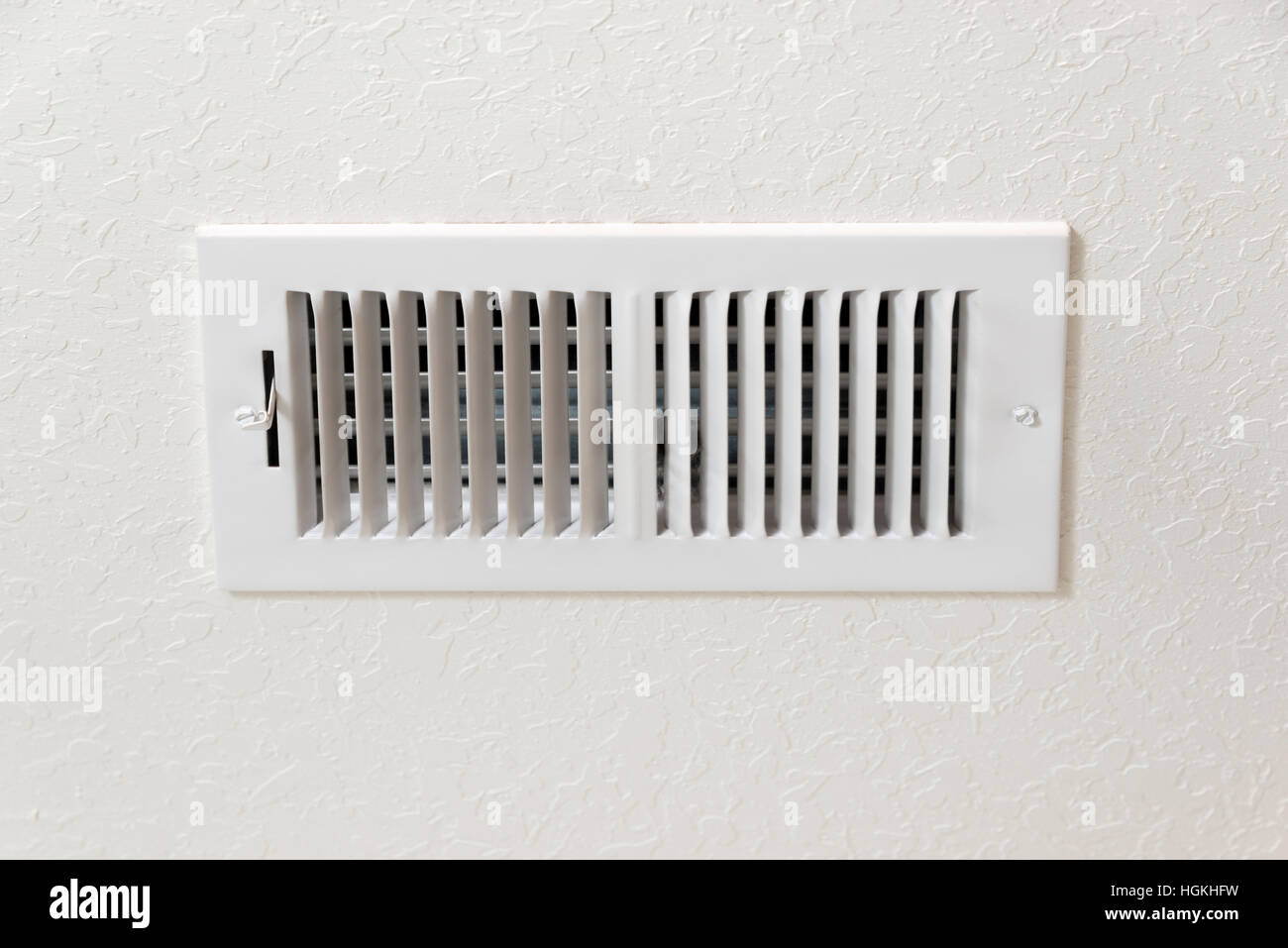 Airconditioning or heating vent in ivorycolored textured wall with