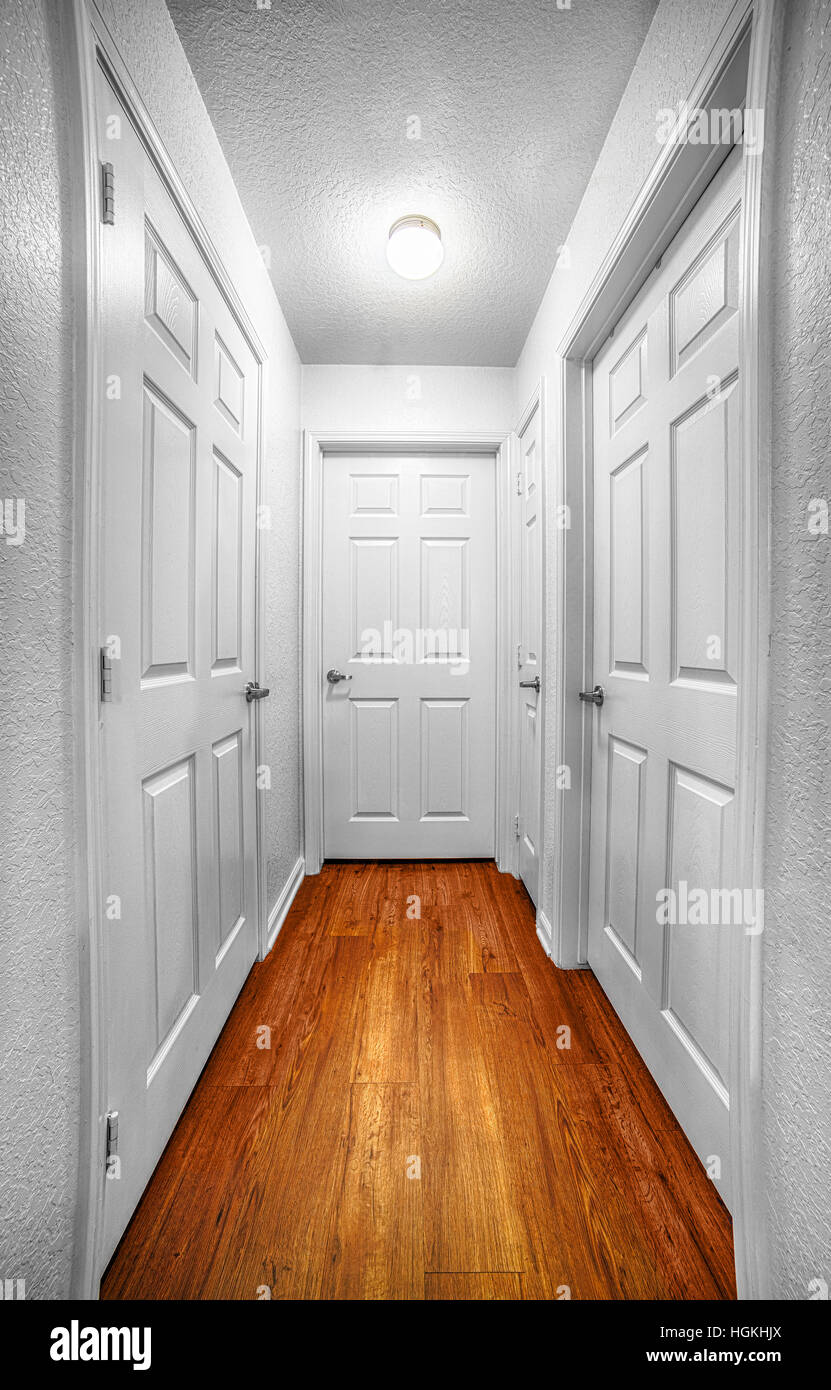 A hallway leads to four different doors, suggesting many choices. Stock Photo