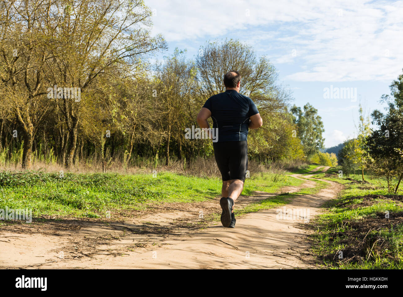 Big belly man jogging , exercising, doing cardio in the park , slightly