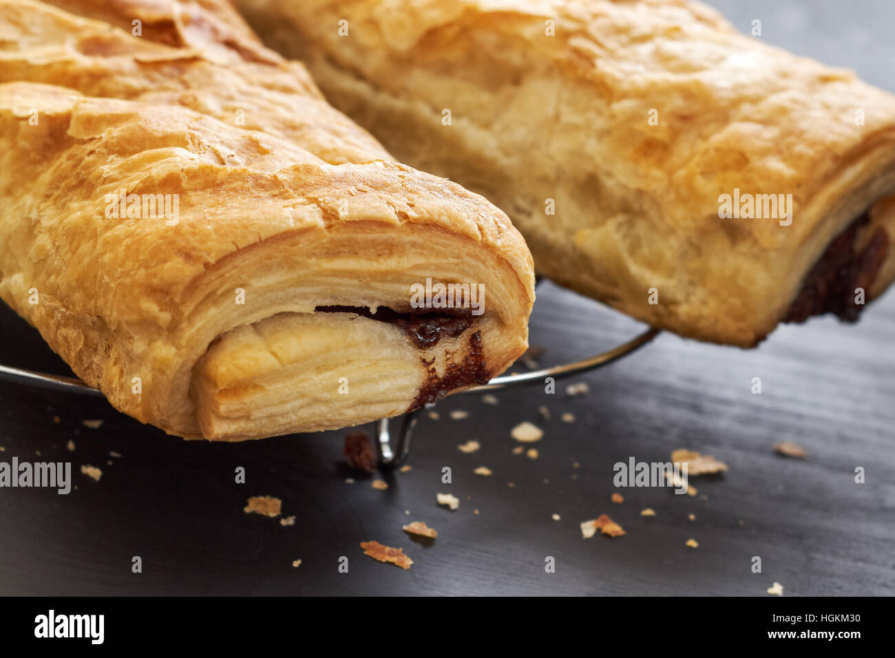 Puff pastry with chocolate filling on black wooden background Stock Photo