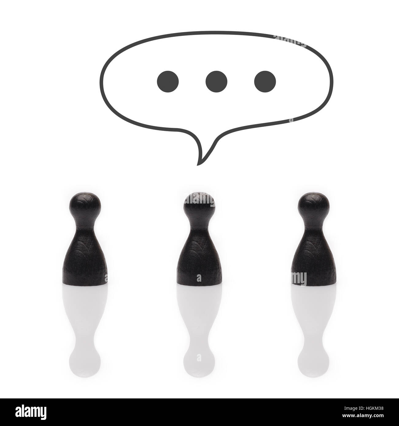 Black pawns with dots in text balloon representing a message being typed Stock Photo