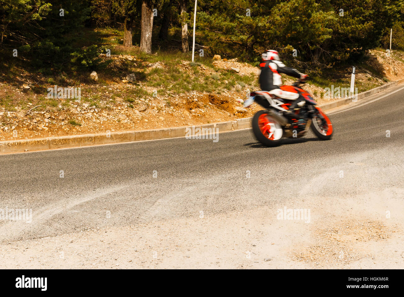 Motor bike racing through the corner of the road, motion unsharpness Stock Photo