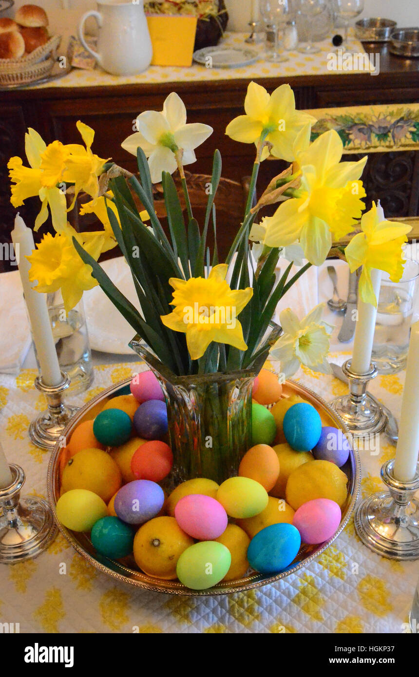 A colorful Easter table center-piece features cut daffodils and dyed Easter eggs. Stock Photo
