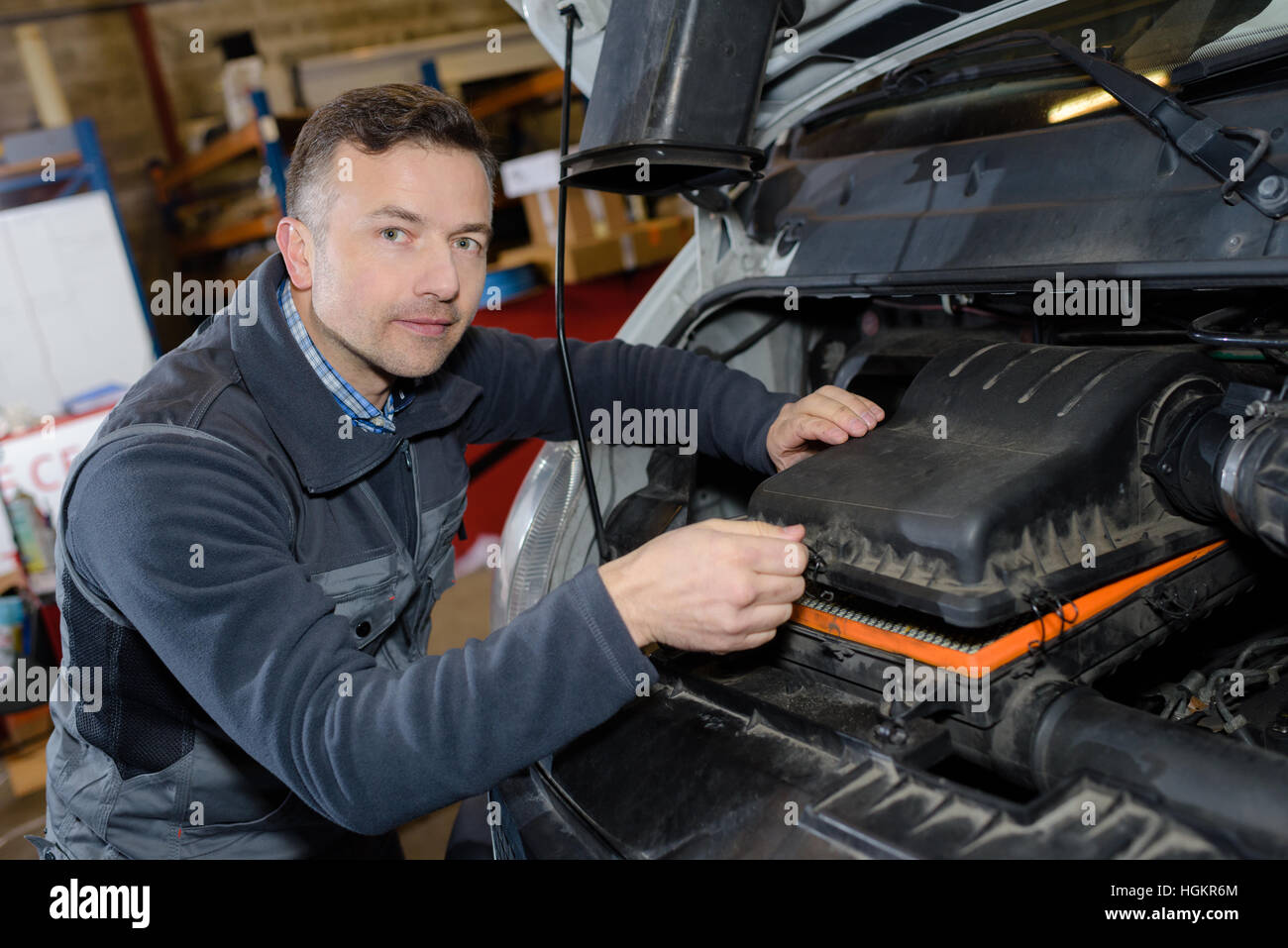 smiling mechanic repairing car engine in a garage Stock Photo - Alamy