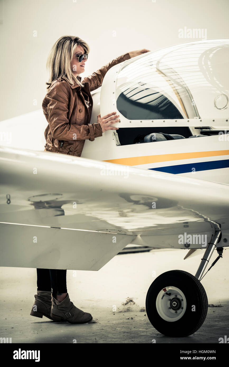 Female pilot closing cockpit of her airplane Stock Photo
