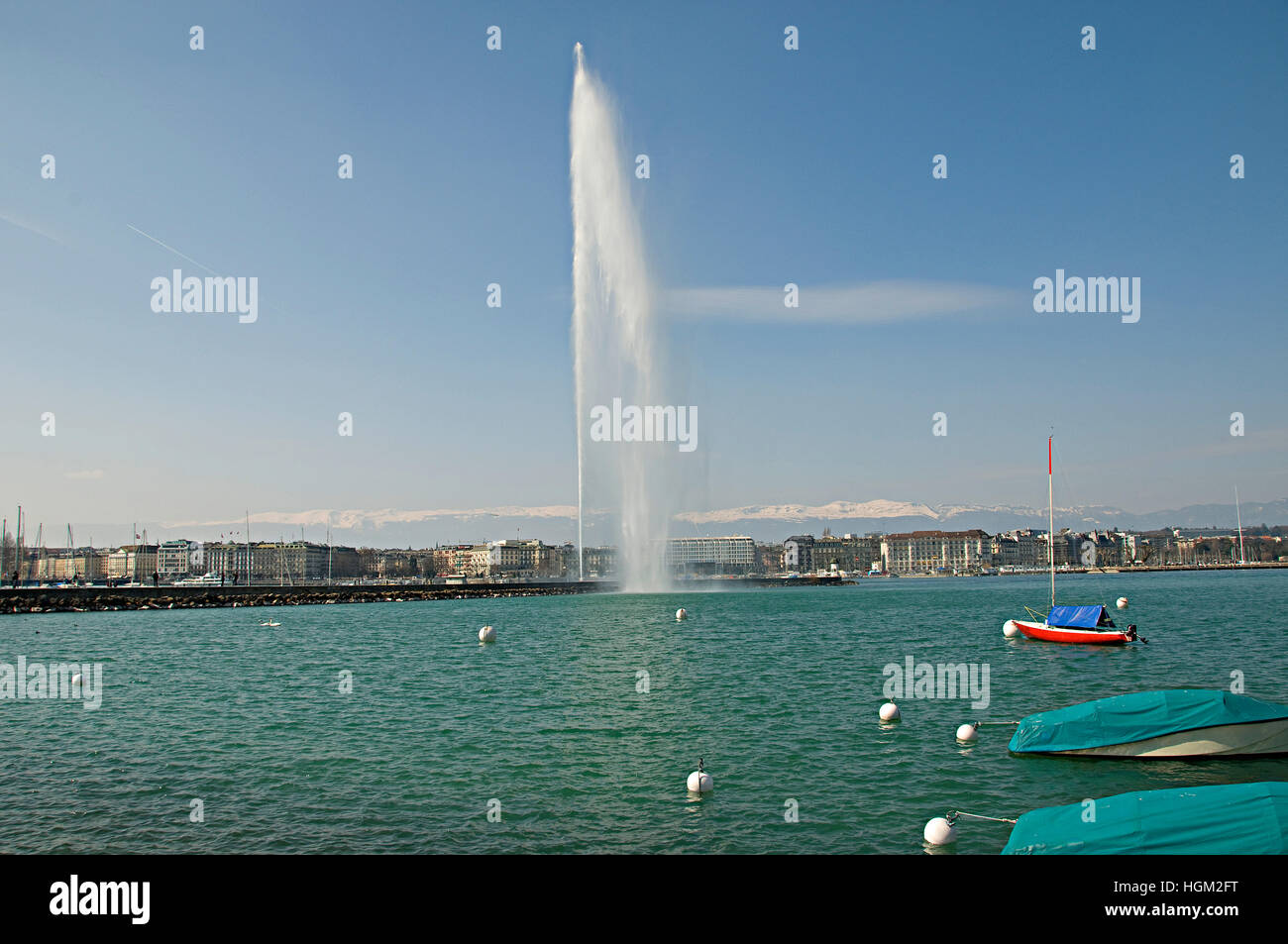 Famous Jet d'Eau fountain in Geneva Switzerland with snow capped Jura mountains in the background. Stock Photo