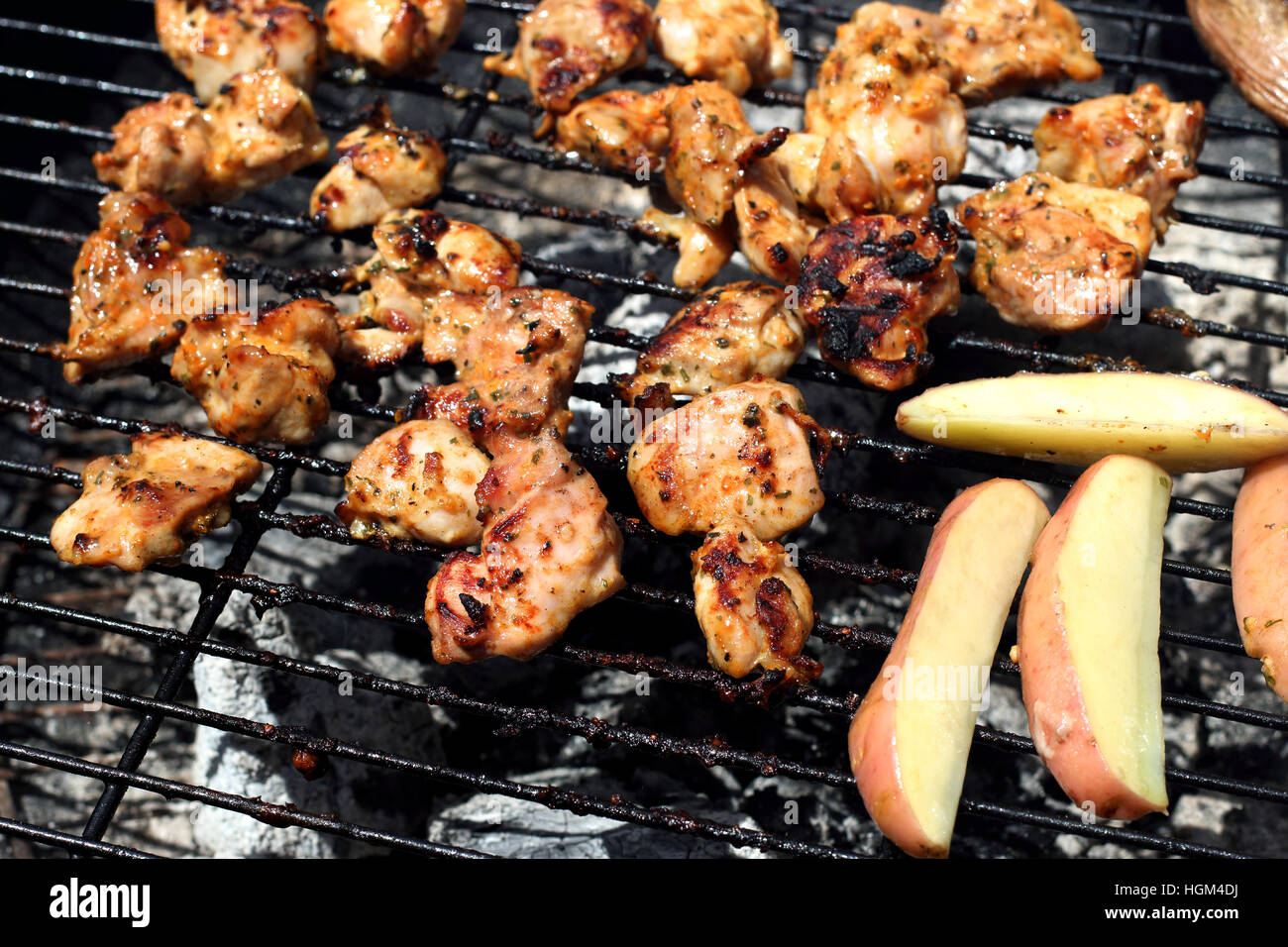 Cooking marinated chicken pieces on a barbecue Stock Photo