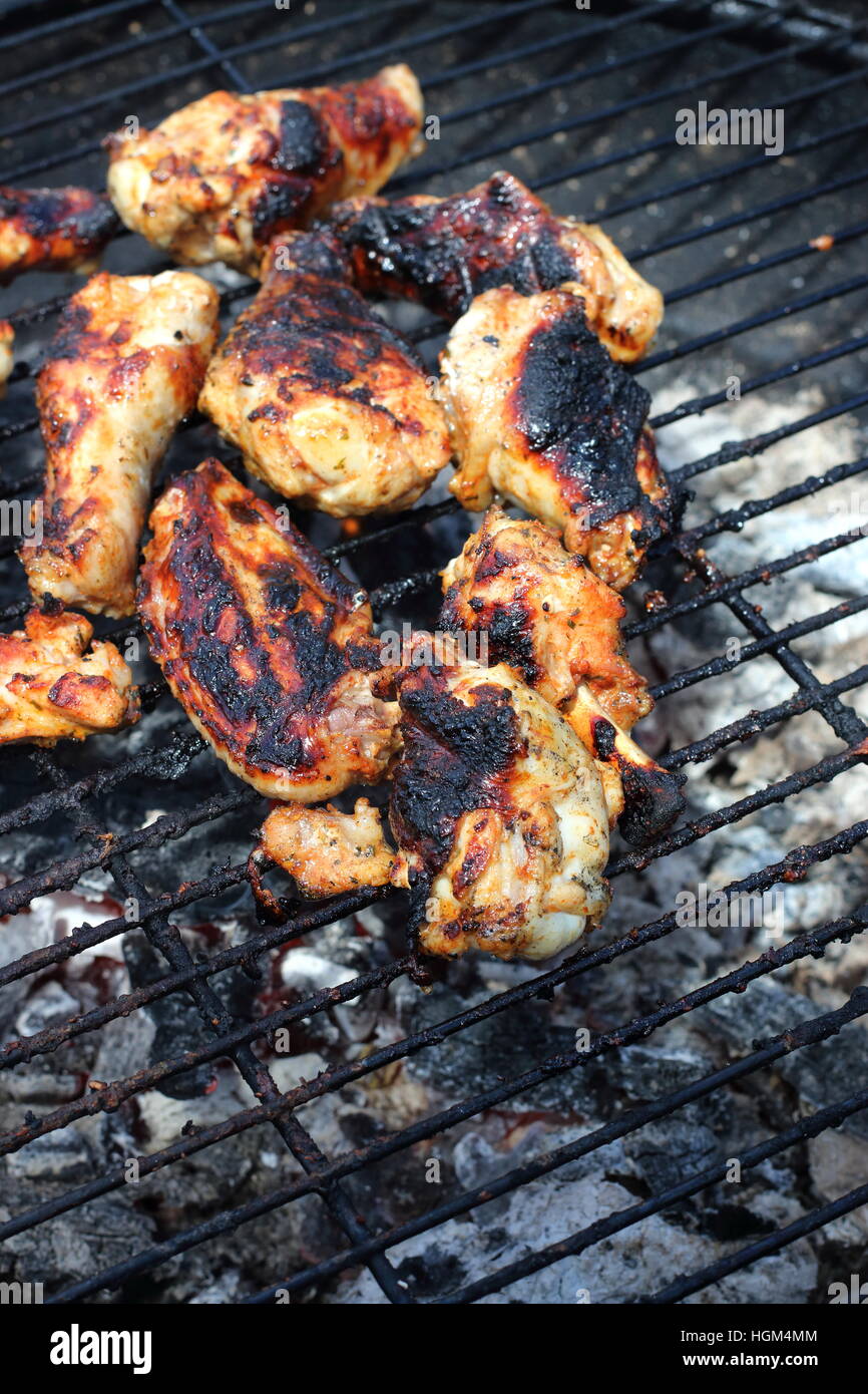 Cooking marinated chicken pieces on a barbecue Stock Photo