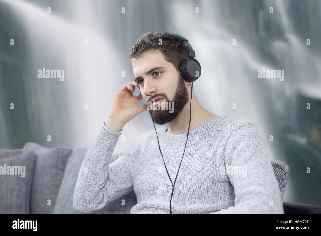 Man listening relaxation music by headset in nature at waterfall Stock Photo