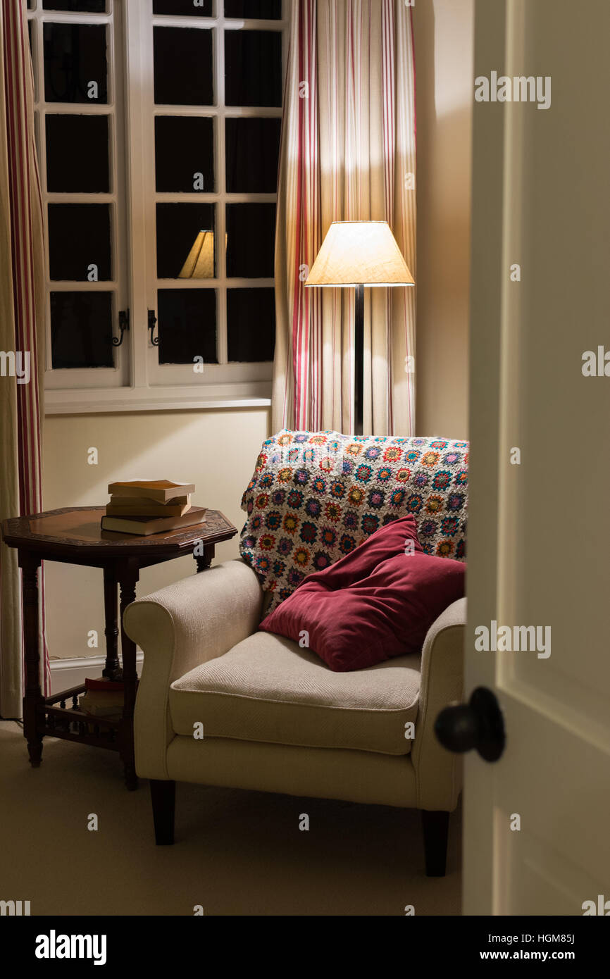 cosy reading chair inside home at night Stock Photo