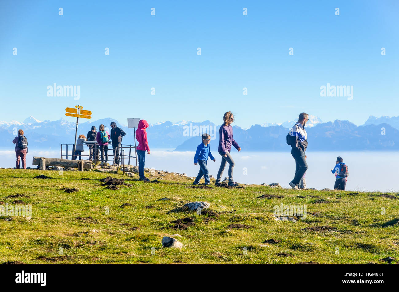 Hikers and Panorama of the Swiss Alps seen from the Dent de Vaulion in the Jura Stock Photo