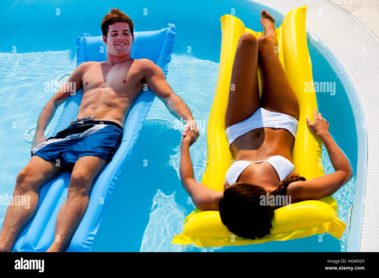 Young couple enjoying floating on pool Stock Photo