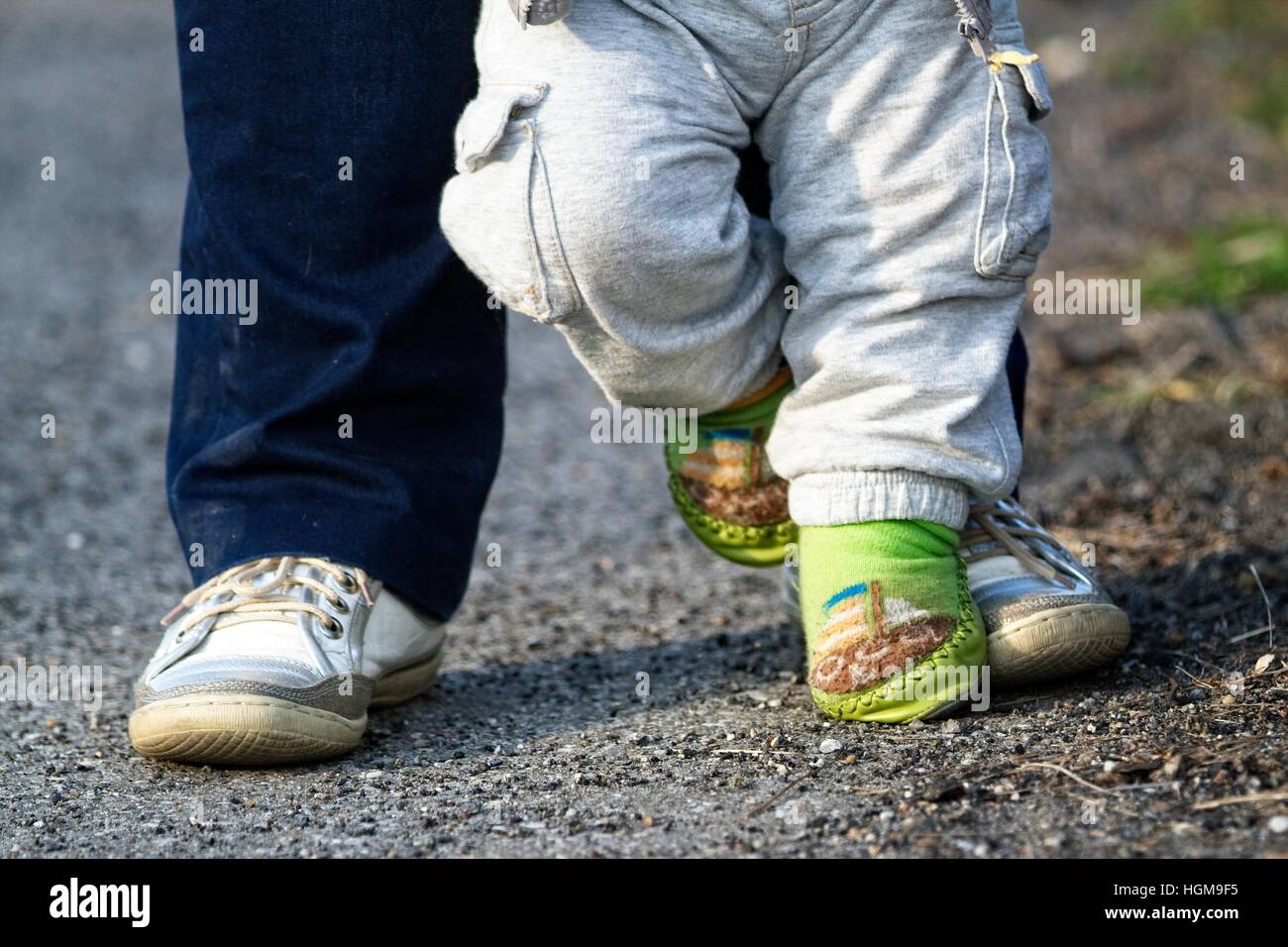 Happy feet - parent and child on the walk for a first time Stock Photo