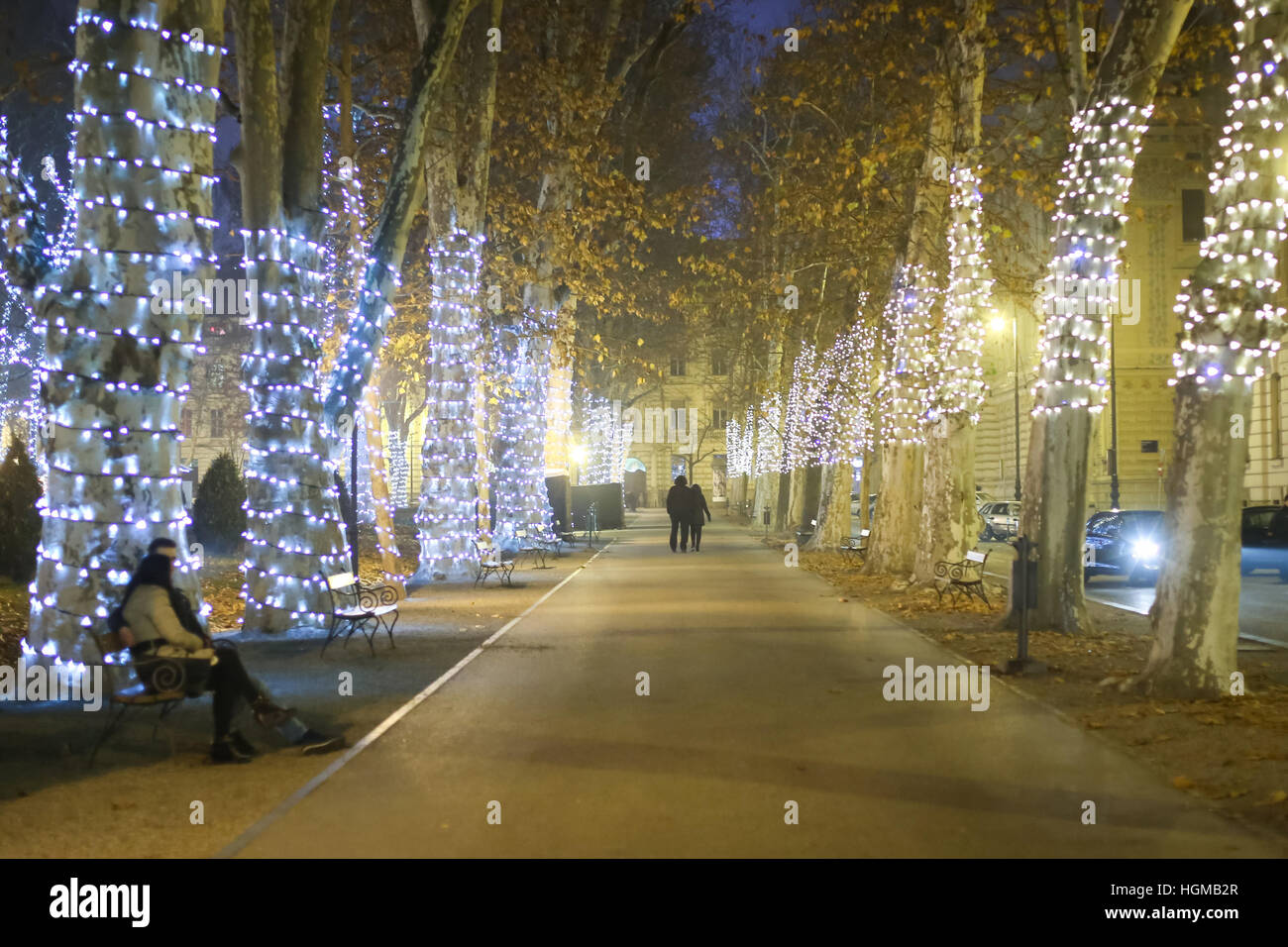 People walking down the illuminated plane tree alley in the ornate Zrinjevac park at advent time. Stock Photo