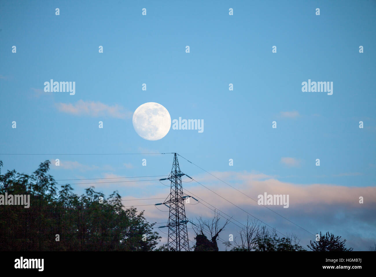 full moon over the electric cables Stock Photo