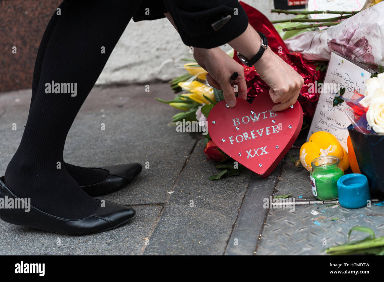 London, UK. 10th January 2017. Fans gather by the mural of David Bowie in artist's birthplace of Brixton to commemorate the first anniversary of musician's death. Brixton's mural which depicts Bowie's face from Aladdin Sane album cover became the major memorial site after the star's death on 10 January 2016. Wiktor Szymanowicz/Alamy Live News Stock Photo