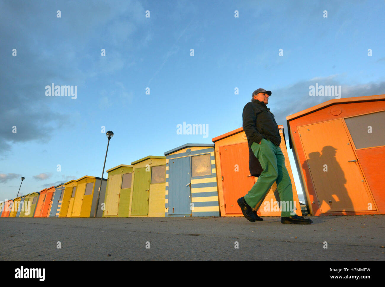 Seaford, East Sussex Sunset illuminates colourful beech huts on Seaford's promenade. Stock Photo