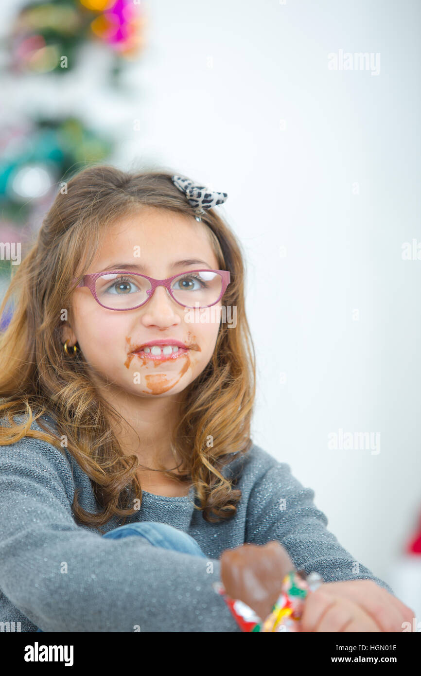 Girl eating chocolate, mouth in a mess Stock Photo Alamy