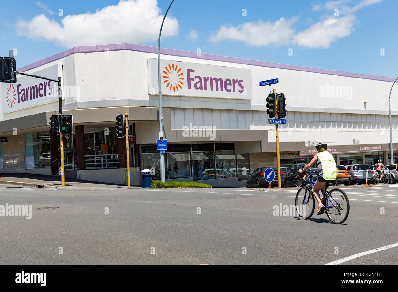 Cyclist passes Farmers department store in Tauranga, New Zealand Stock