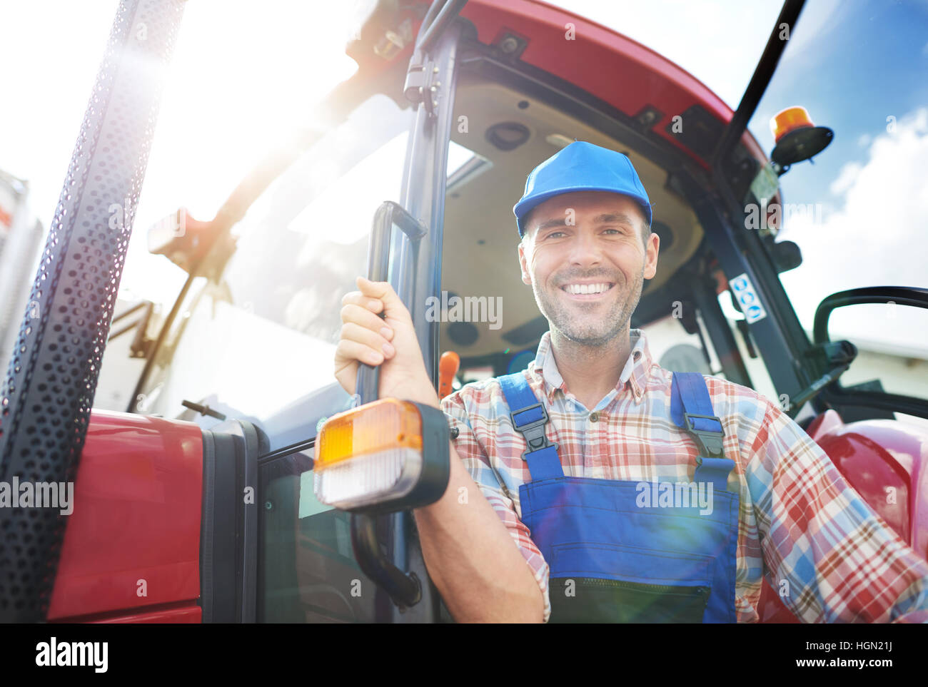 Farmer sitting on his tractor Stock Photo - Alamy