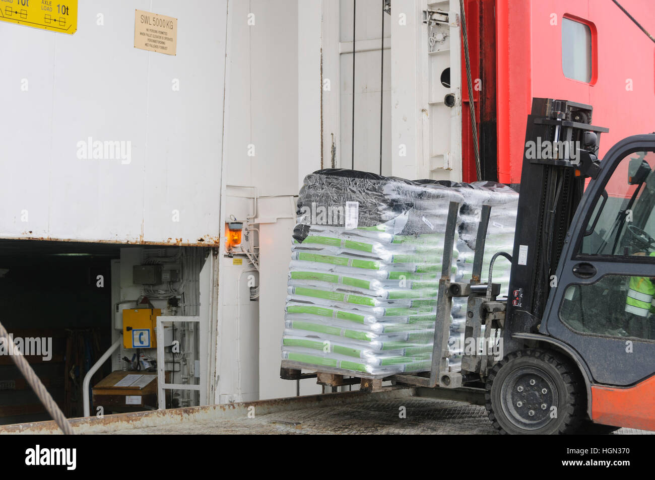 Fork lift loading goods on a ship Stock Photo