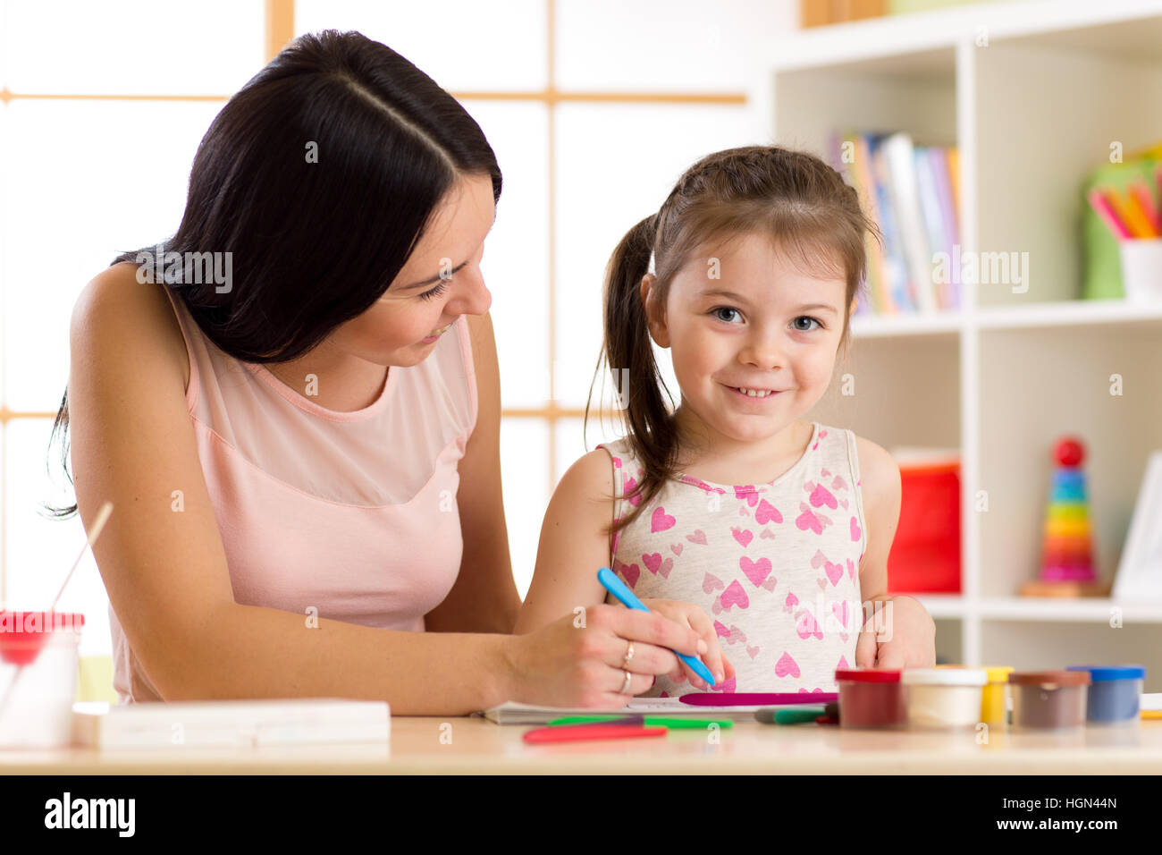 happy mother and kid daughter painting with pencils Stock Photo