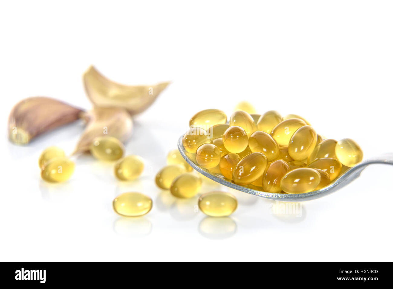 Garlic oil capsules with garlic cloves isolated on white background