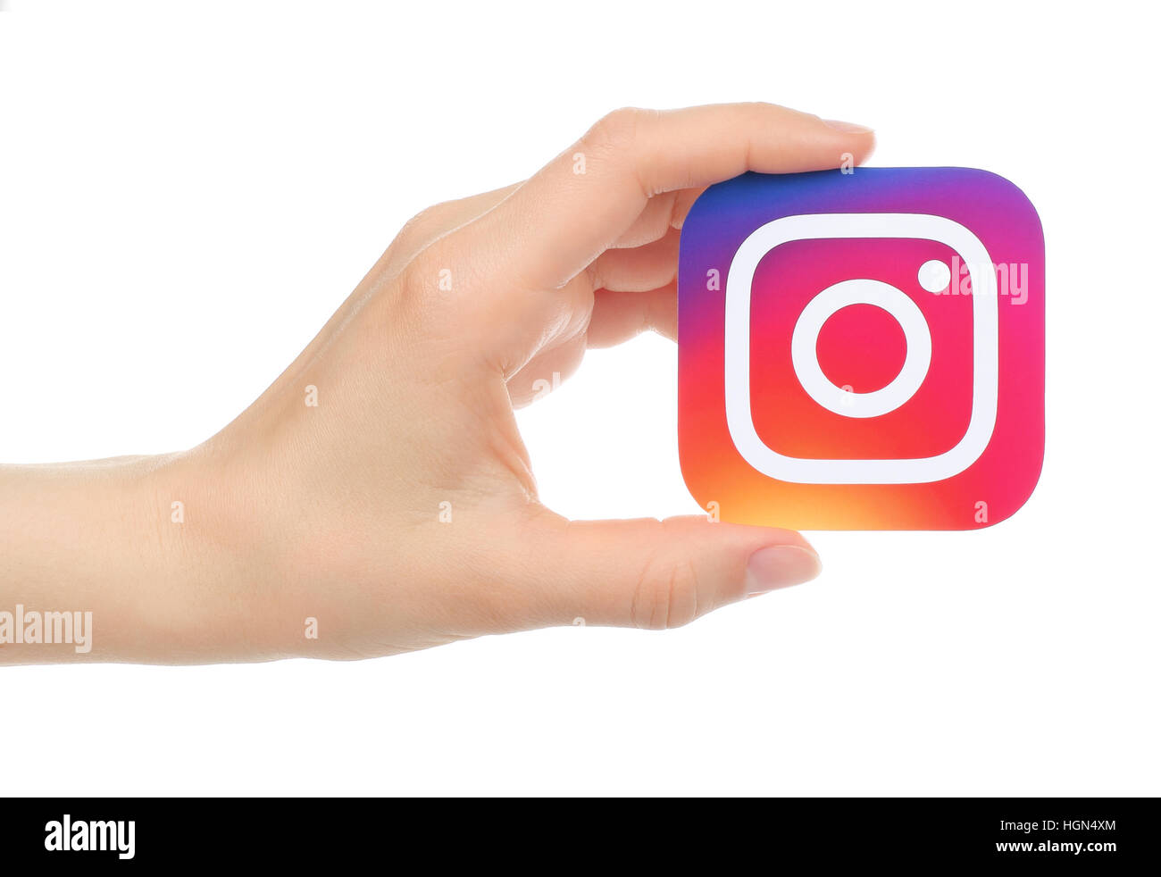 Kiev, Ukraine - May 17, 2016: Hand holds new Instagram logo printed on paper, on white background. Instagram is an online mobile photo-sharing, video- Stock Photo