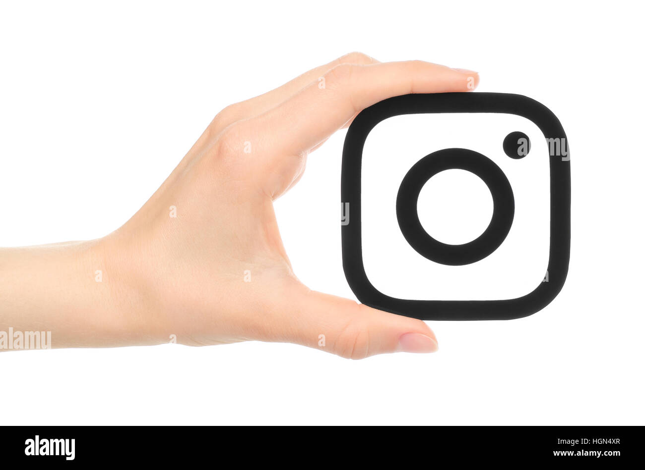 Kiev, Ukraine - May 17, 2016: Hand holds new Instagram logo printed on paper, on white background. Instagram is an online mobile photo-sharing, video- Stock Photo