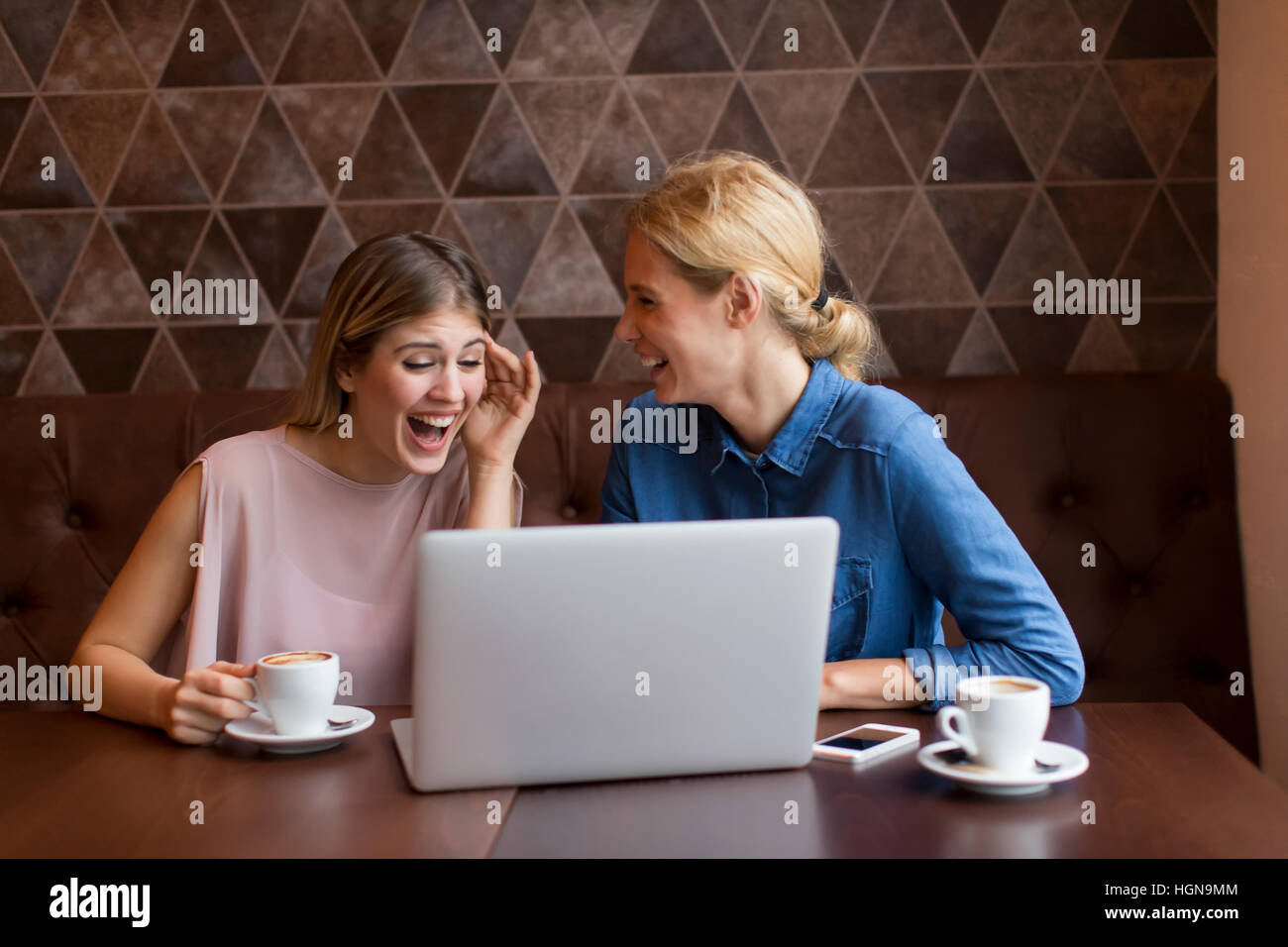 Two attractive young women drinking coffee in the cafe Stock Photo - Alamy