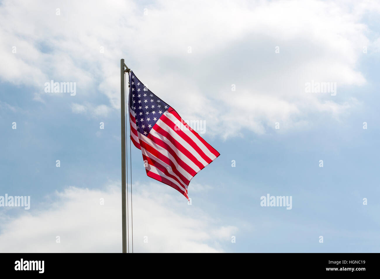 Flag of United States on a flagpole in front of blue sky Stock Photo ...