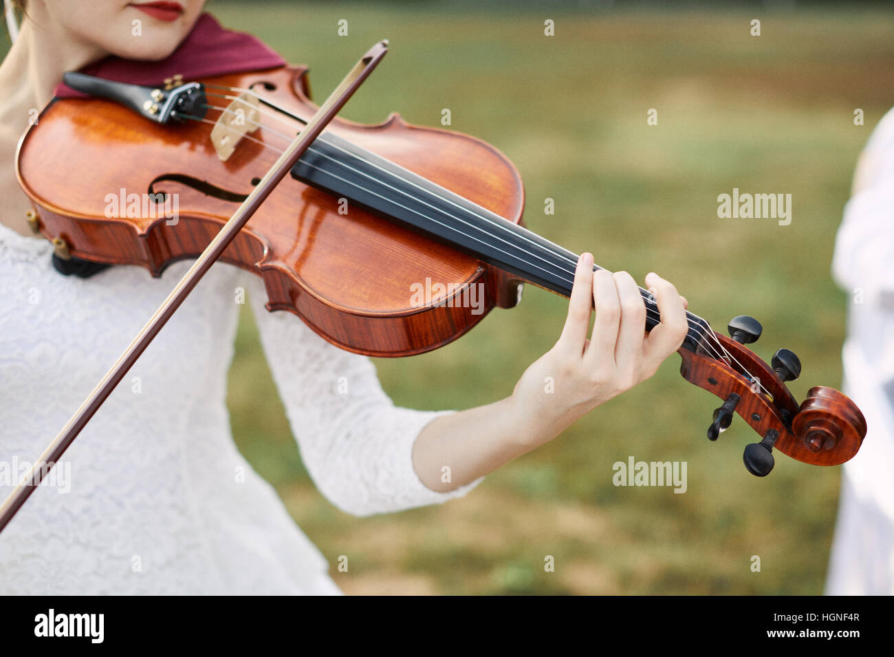 Violinist woman. Young woman playing a violin outside. Stock Photo