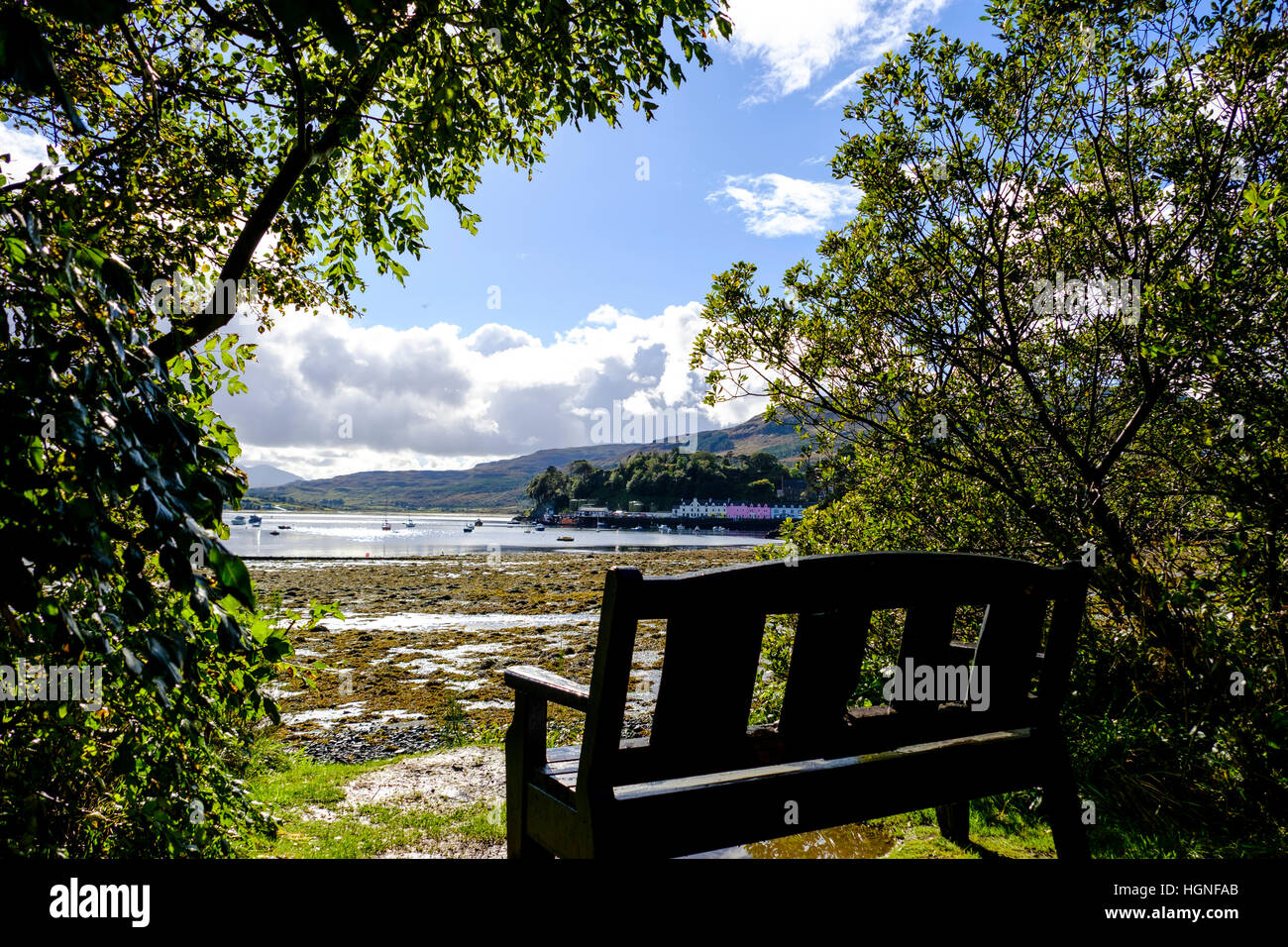 Bench with a view to the coloful buildings on the harbor at Portree ...