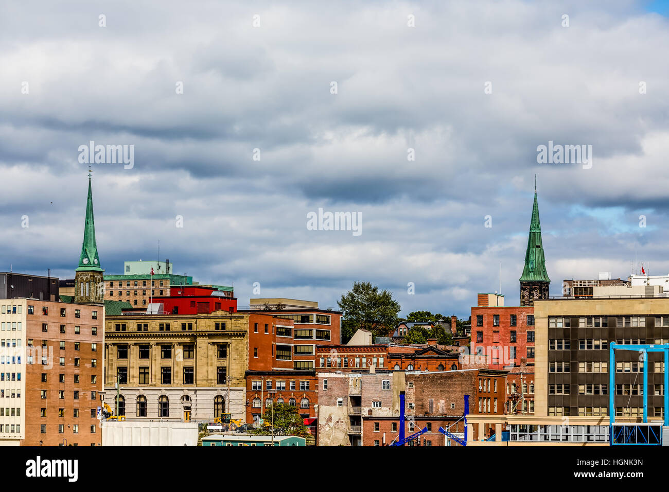 Two green church steeples above old brick buildings in Saint John, New Brunswick, Canada Stock Photo