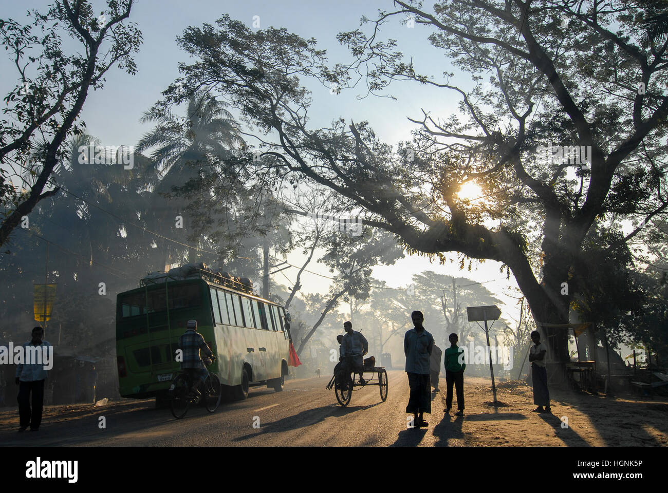 BANGLADESH, Khulna District, morning mist at road in village, Bus and bicycle rikshaw / BANGLADESCH Khulna , Menschen, Rikscha und Bus im Morgennebel auf einer Strasse in einem Dorf Stock Photo