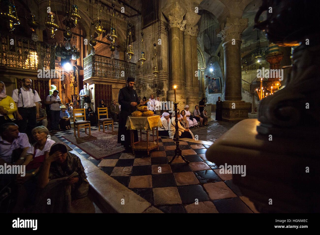 Jerusalem, Israel - July 13, 2014: Greek Orthodox priest holds mass in front of the Aedicula, place believed to be the tomb of Christ. Stock Photo