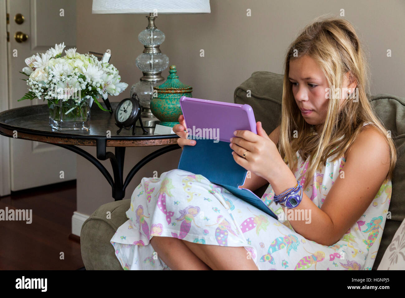Eleven-year-old Girl Playing a game on iPad. Stock Photo