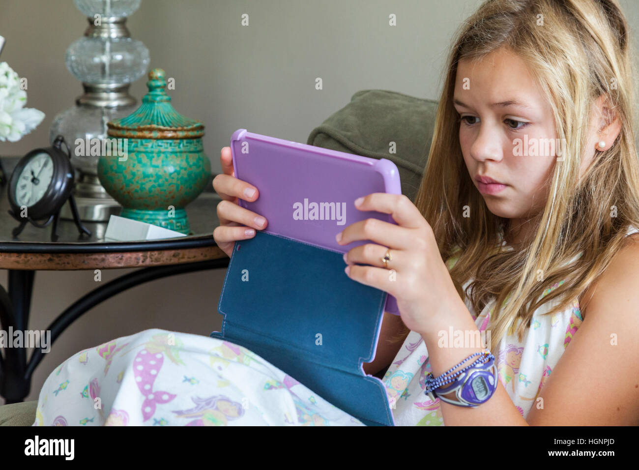 Eleven-year-old Girl Playing a game on iPad. Stock Photo