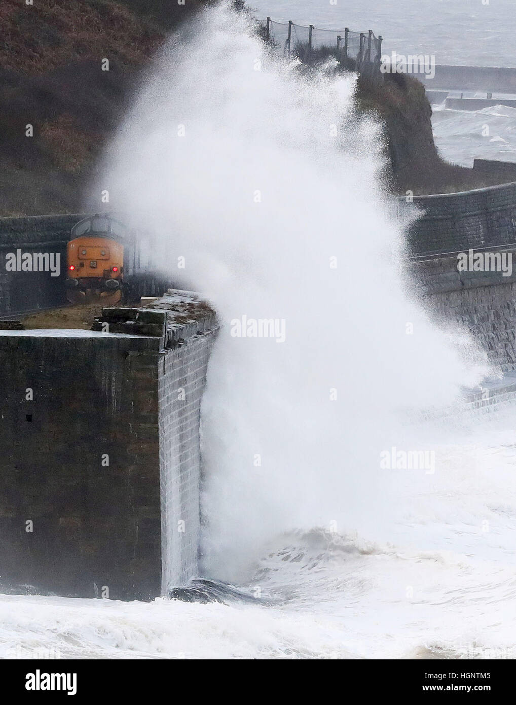 Waves crash against the sea wall near Whitehaven in Cumbria, as high winds have brought travel chaos and power cuts as they buffet some parts of the country. Stock Photo