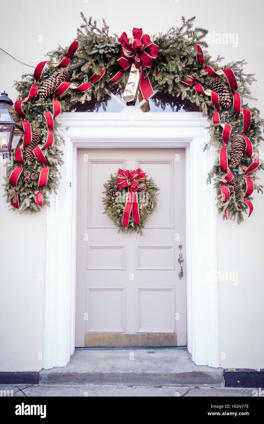 A beautiful door is decorated for Christmas with an evergreen wreath ...