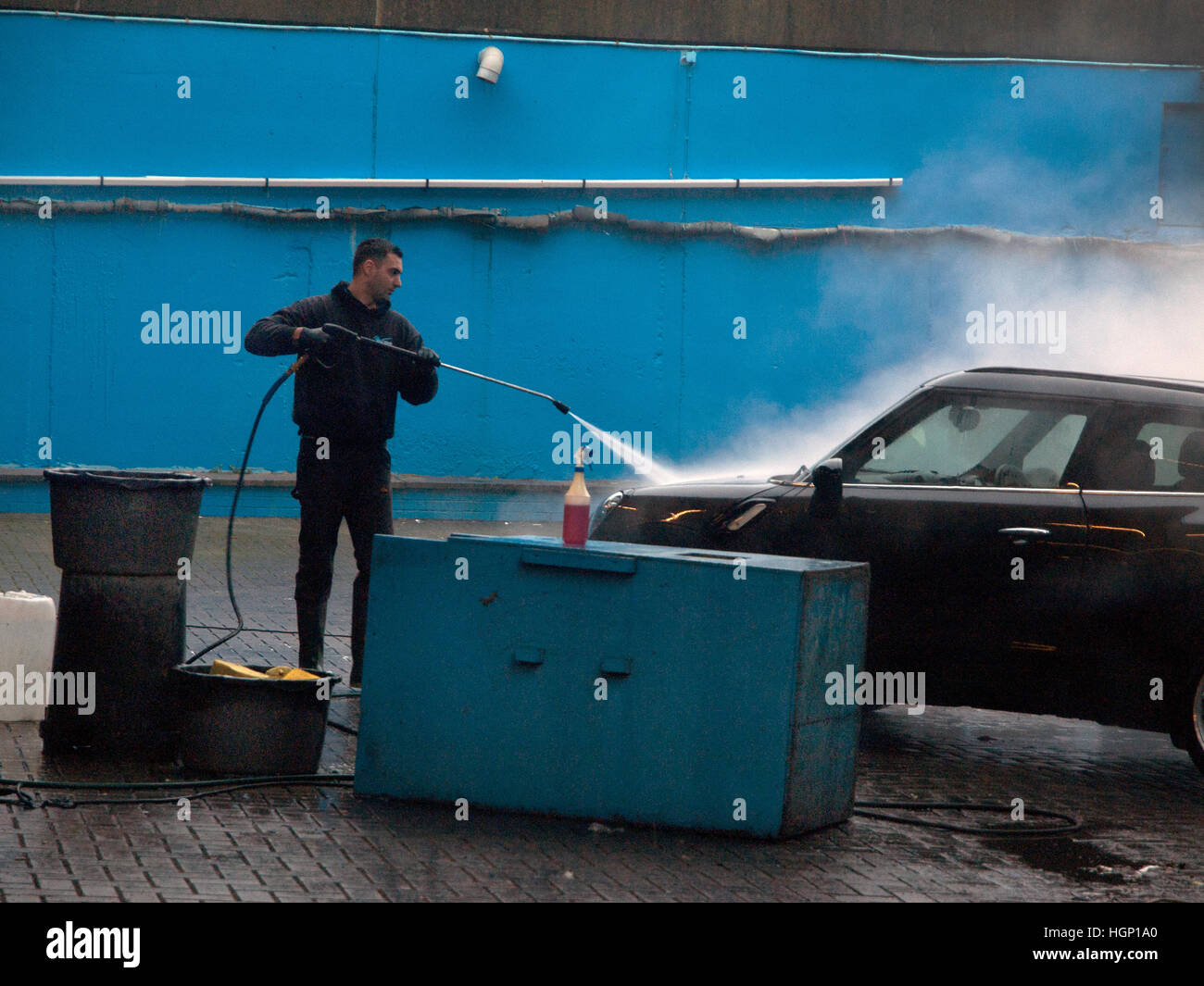 A car cleaner at work with a high powered hose Stock Photo Alamy