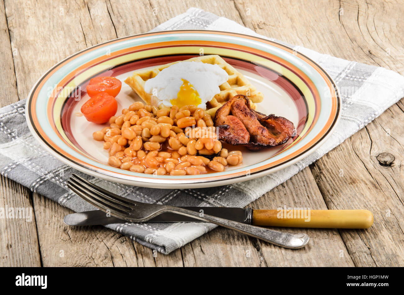 scottish breakfast with baked beans, fried bacon, tomatoes, waffle with