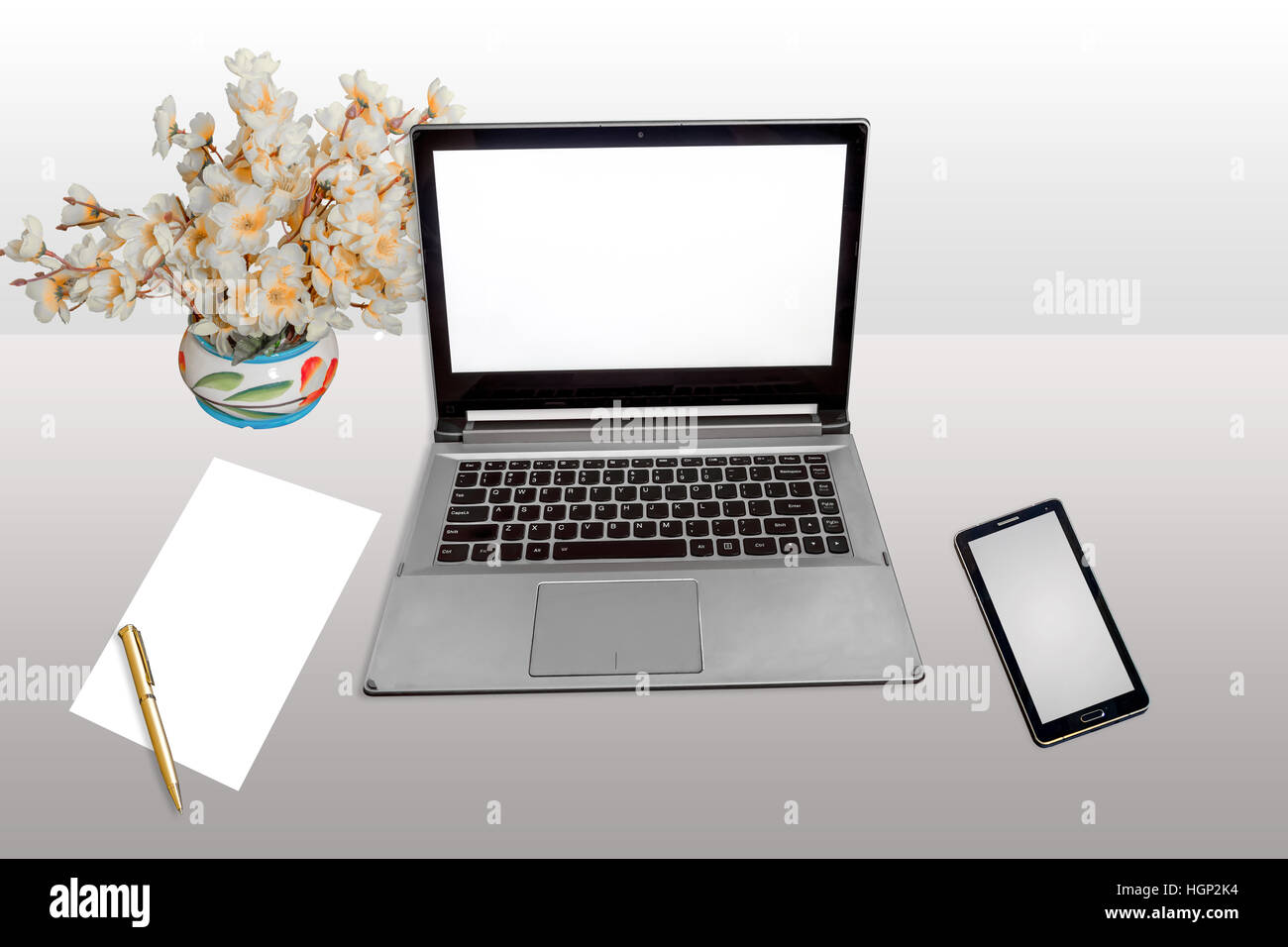 Work place with laptop white screen, smart phone, white blank paper and pen isolated. Stock Photo