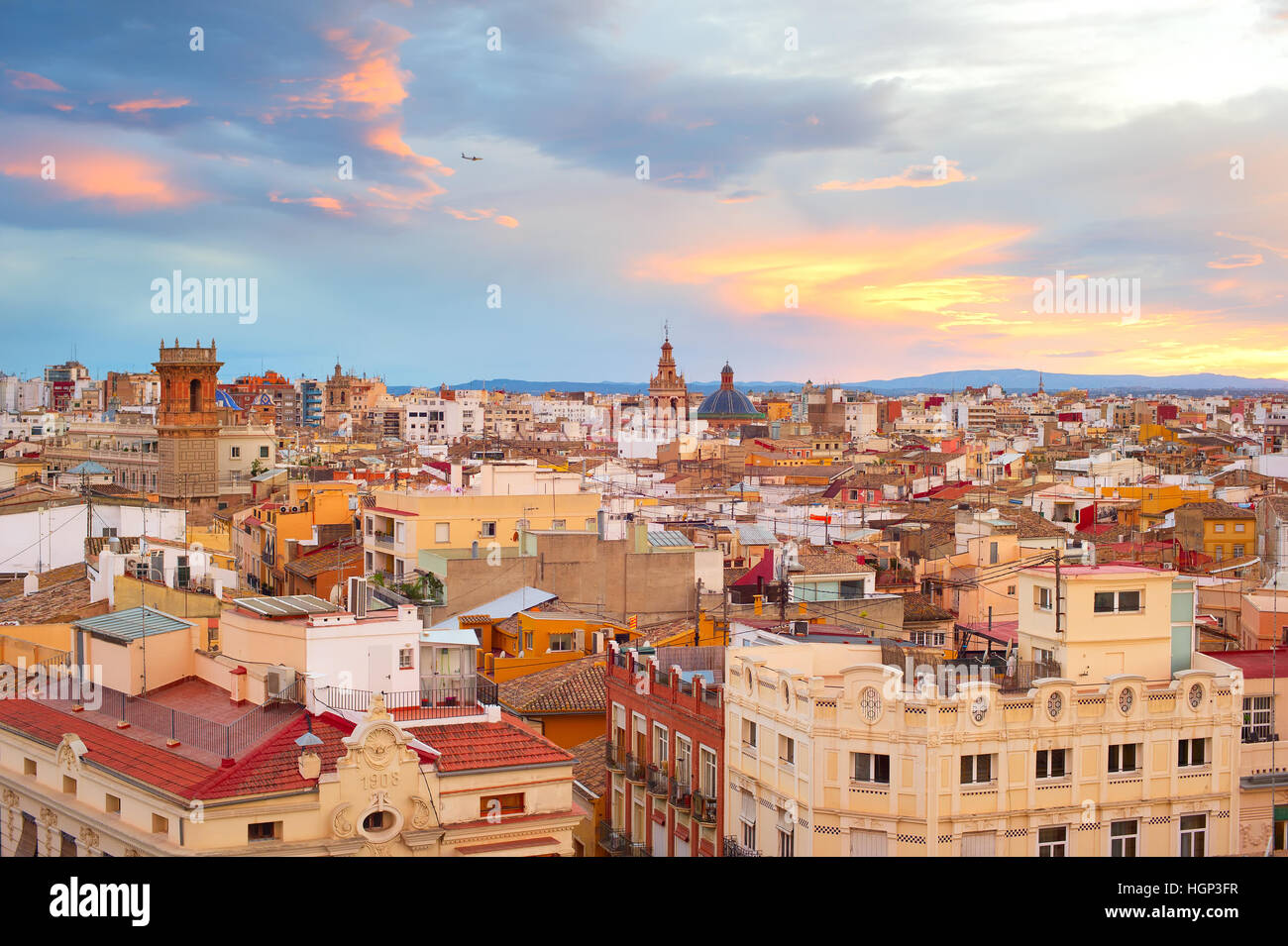 Old Town of Valencia at sunset. Plane flying in the sky. Spain Stock Photo